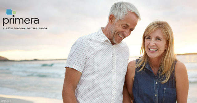 Middle aged couple sharing a laugh at the beach