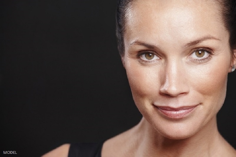 Smiling middle aged woman with beautiful eyes against black backround