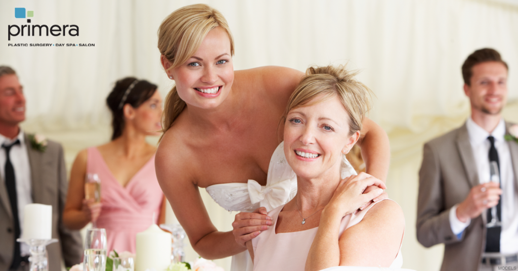attractive bride with mom smiling at camera