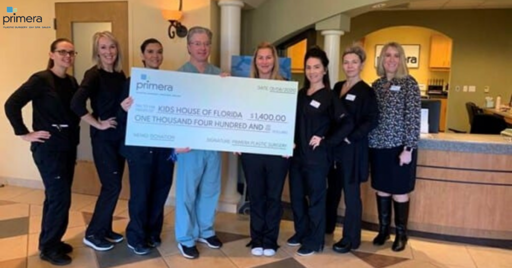 Dr. Gross with staff holding oversized $1,400 check to Kids house of florida