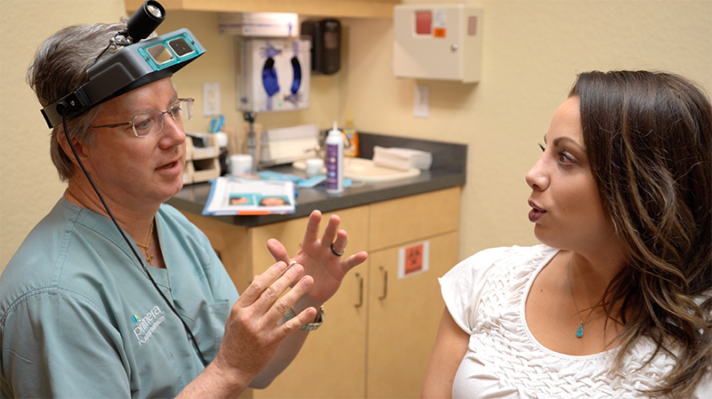 Dr. Gross in scrubs discussing procedure with patient