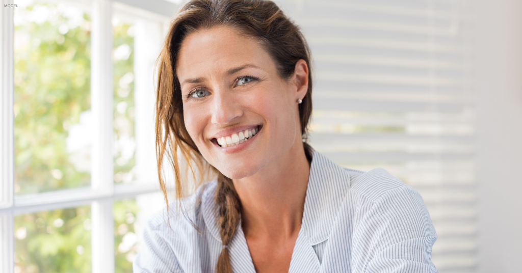 Woman sitting by a window smiling in Orlando, Florida