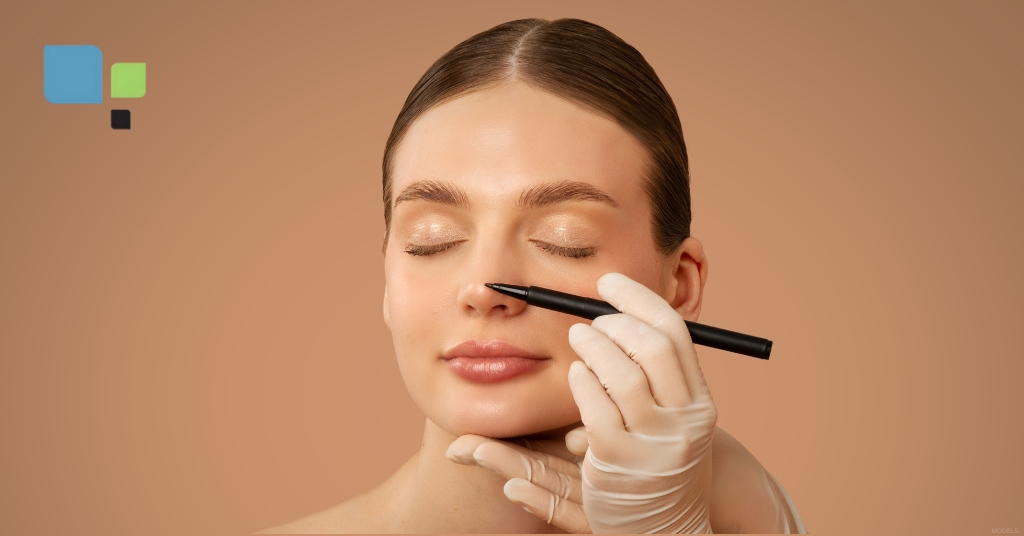 Close-up of a young woman preparing for rhinoplasty, with surgical markings on her nose (models), brown studio backdrop. Primera Plastic Surgery Logo