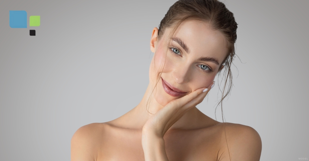 A young woman posing with her hand on her face (model) Primera Plastic Surgery Logo